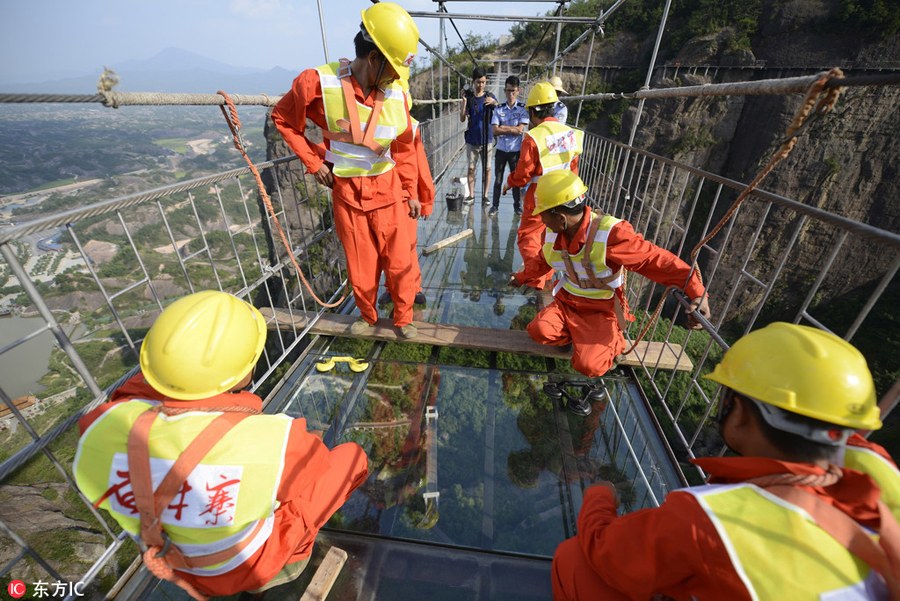 Só para corajosos: Trabalhadores chineses substituem vidro em ponte suspensa a 180 metros do nível do solo