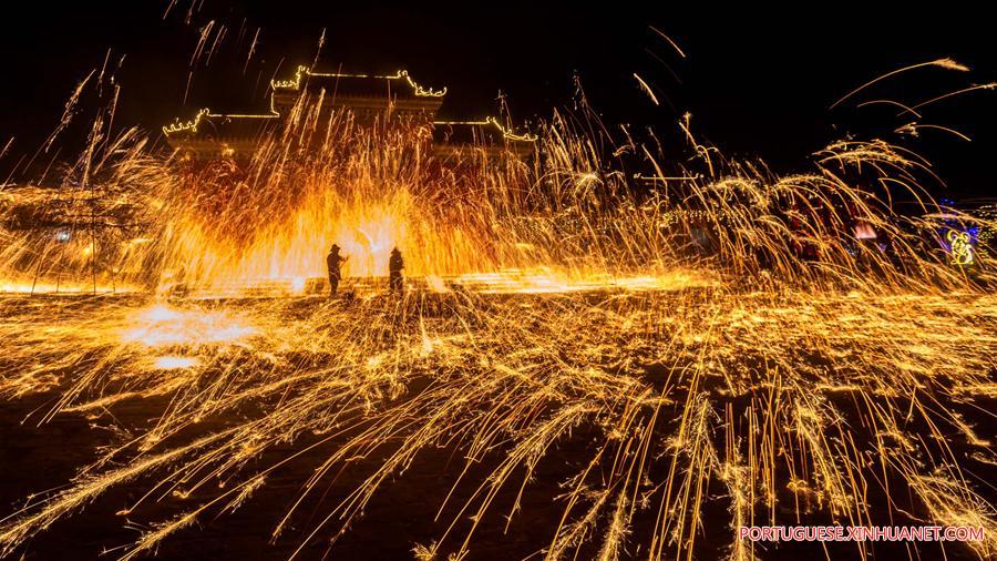 Excutantes espalham ferro derretido quente para simular a exposi??o dos fogos de artifício em Neihuang