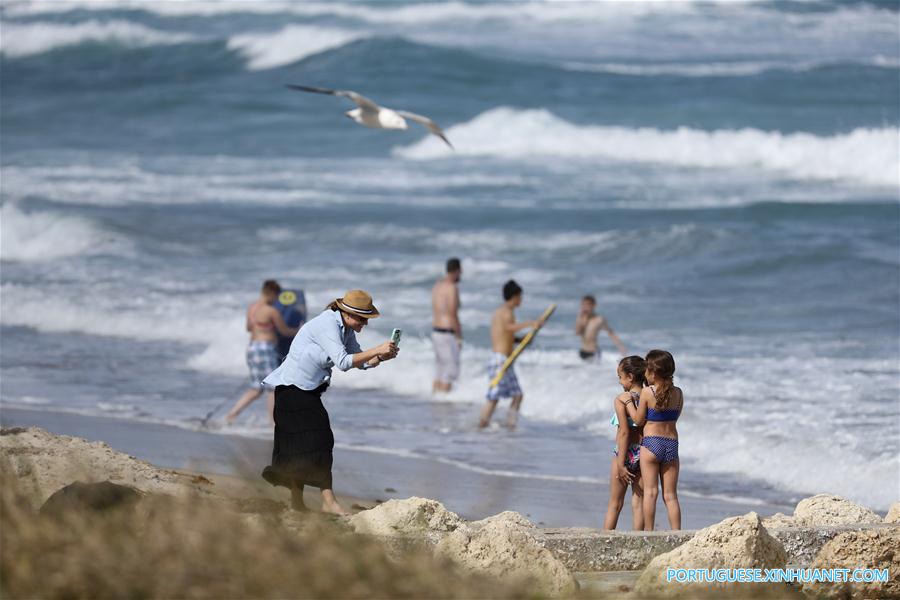 Mulher tira foto de suas filhas à beira da praia em Palm Beach, Flórida, Estados Unidos, em 24 de mar?o de 2017. 
