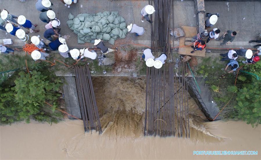 Caminh?o reboque é utilizado para bloquear passagem de água em regi?o alagada em Changsha