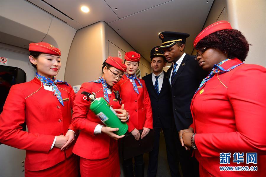 Voluntários estrangeiros juntam-se ao staff dos trens chineses durante migra??o do Ano Novo