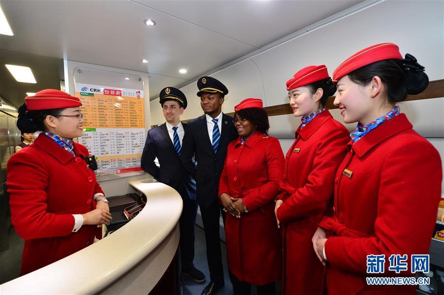 Voluntários estrangeiros juntam-se ao staff dos trens chineses durante migra??o do Ano Novo