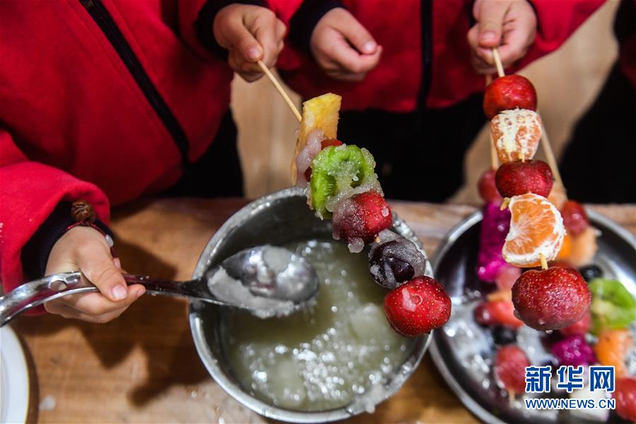 Crian?as confecionam iguarias tradicionais para receber termo solar “Xiaoxue” em Zhejiang