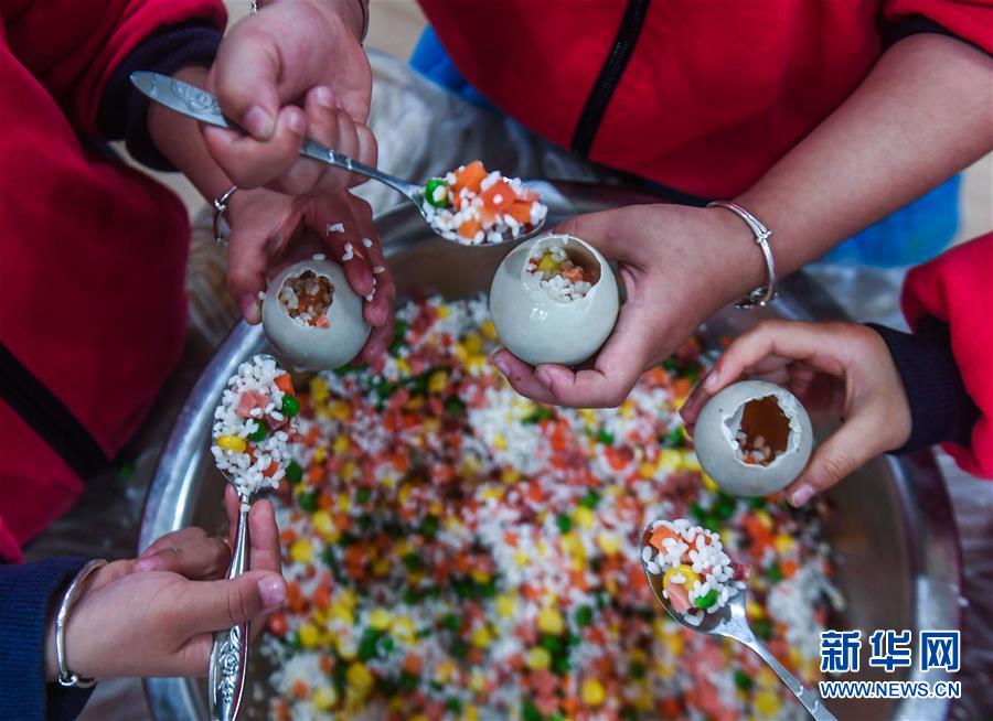 Crian?as confecionam iguarias tradicionais para receber termo solar “Xiaoxue” em Zhejiang