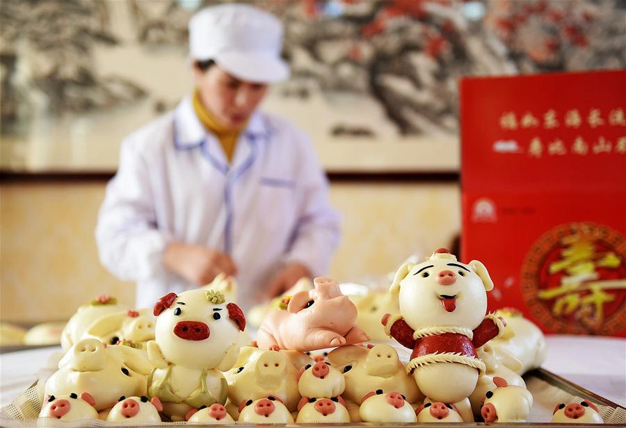 Alde?es fazem p?es cozidos no vapor em formato de porco para saudar Ano Novo Lunar