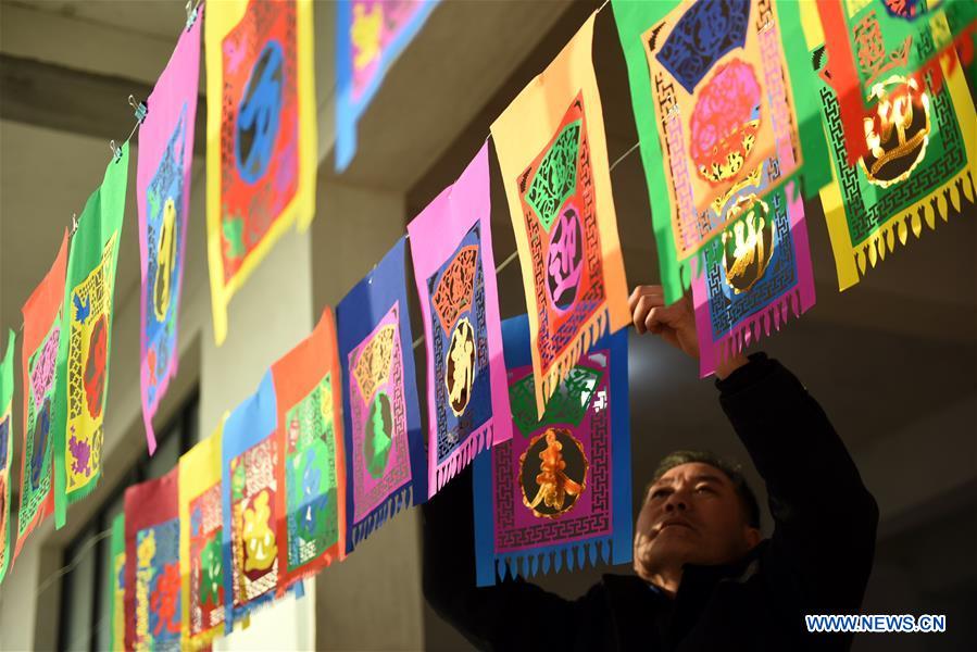 Shandong: Artes?os preparam trabalhos de recorte de papel para receber o Festival da Primavera