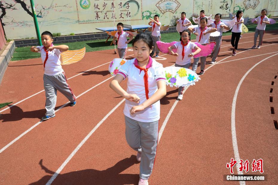 China: alunos de escola primária usam “asa de um metro” para manter distanciamento

