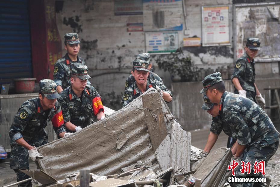 Oficiais e soldados limpam lama depois da inunda??o em Chongqing