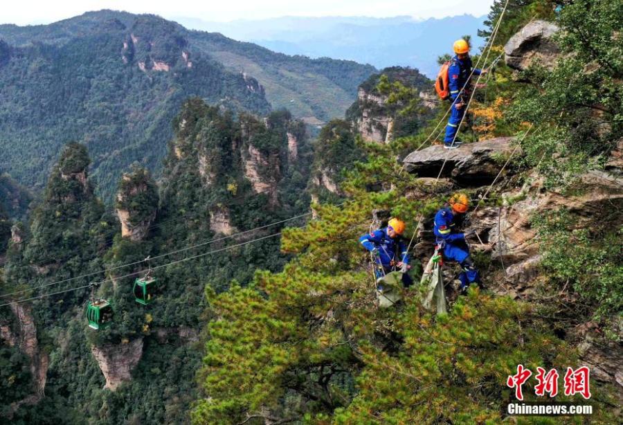 Equipe de resgate Blue Sky retira lixo em penhasco de Zhangjiajie