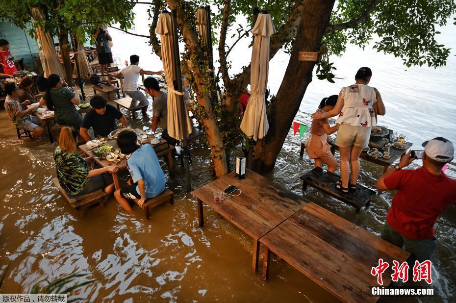 Tailandia: clientes comem em restaurante inundado