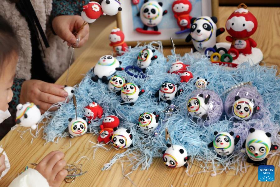 Crian?as fazem Bing Dwen Dwen com argila colorida em Shanghai