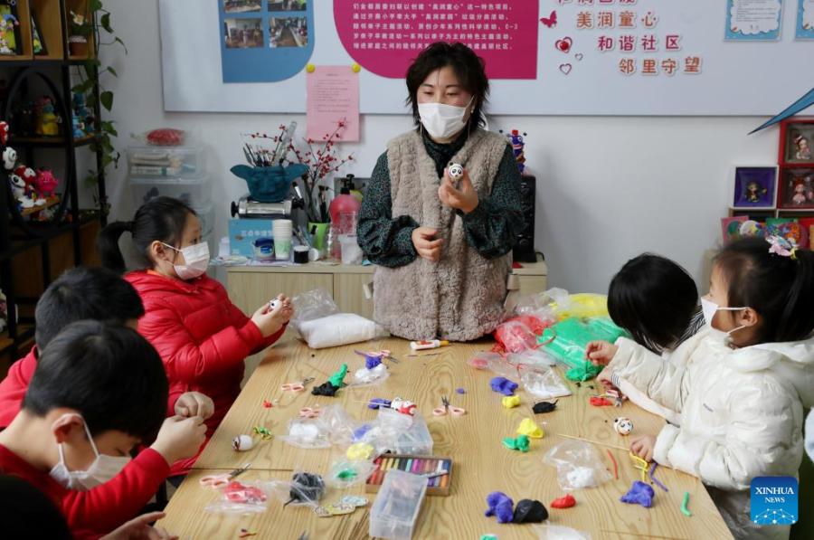 Crian?as fazem Bing Dwen Dwen com argila colorida em Shanghai