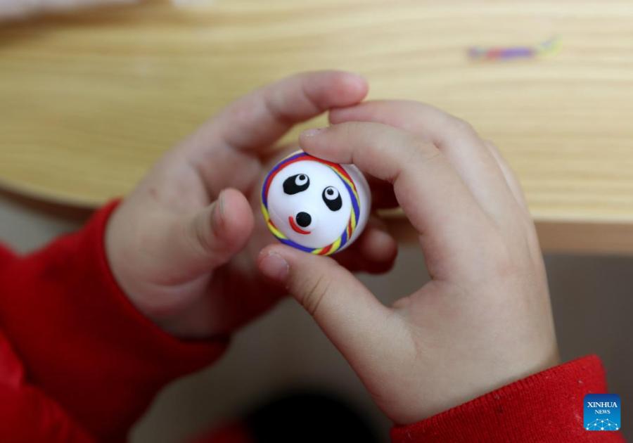 Crian?as fazem Bing Dwen Dwen com argila colorida em Shanghai