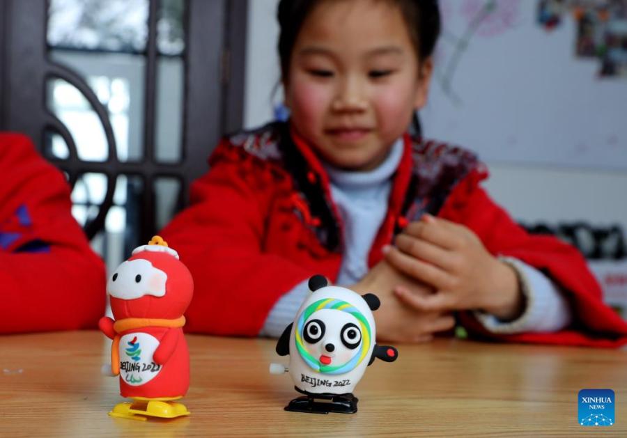 Crian?as fazem Bing Dwen Dwen com argila colorida em Shanghai