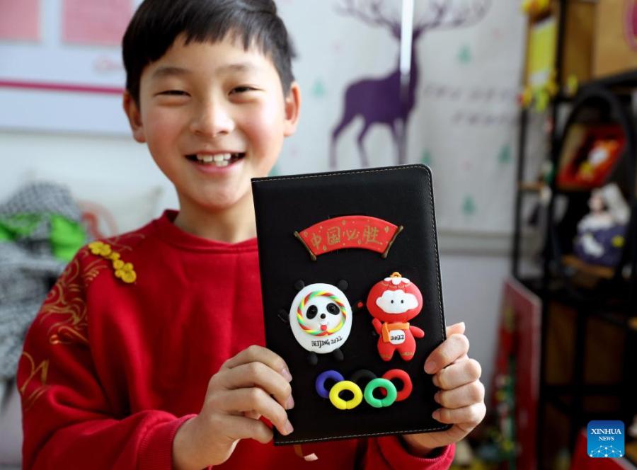 Crian?as fazem Bing Dwen Dwen com argila colorida em Shanghai