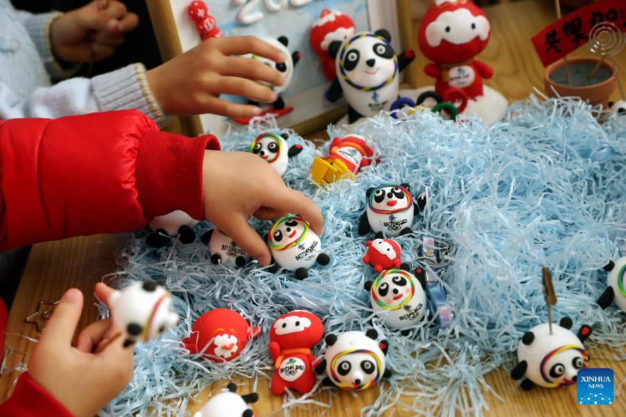 Crian?as fazem Bing Dwen Dwen com argila colorida em Shanghai