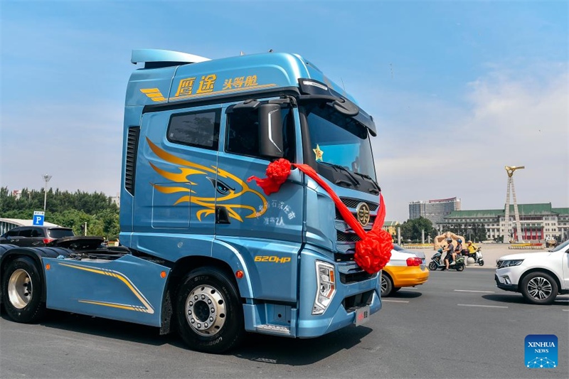 Caminh?es Jiefang de diferentes gera??es desfilam para celebrar 70o aniversário do Grupo FAW