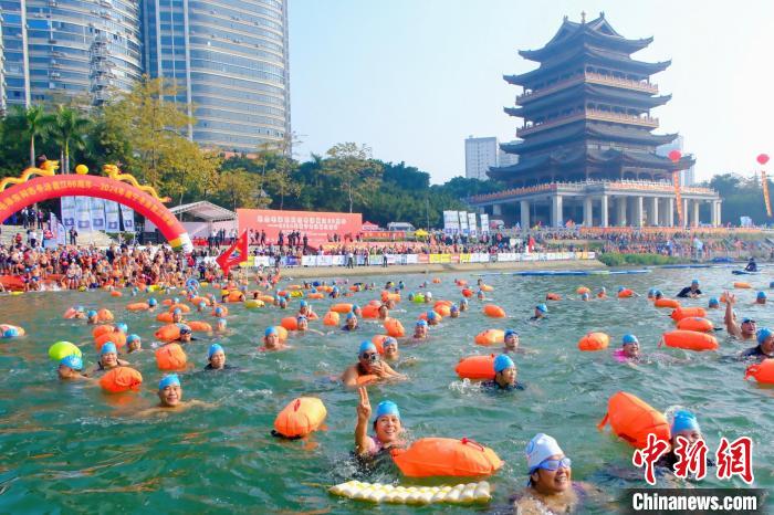 Mais de 3.000 entusiastas da nata??o atravessam rio Yongjiang, no sul da China