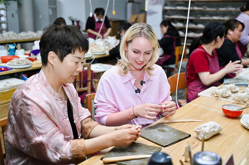 Jornalistas da Eurásia experienciam charme único da porcelana de pe?nia de Luoyang