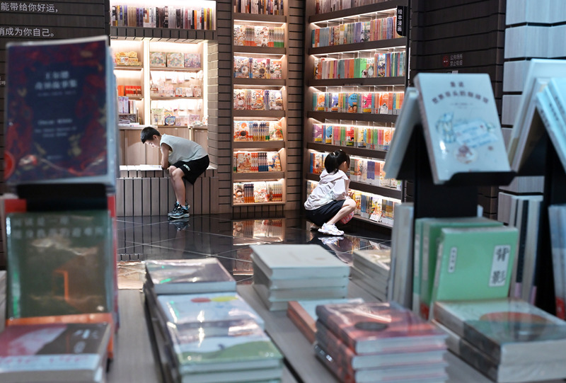 Shijiazhuang: crian?as chinesas leem livros em livraria para passar as férias de ver?o
