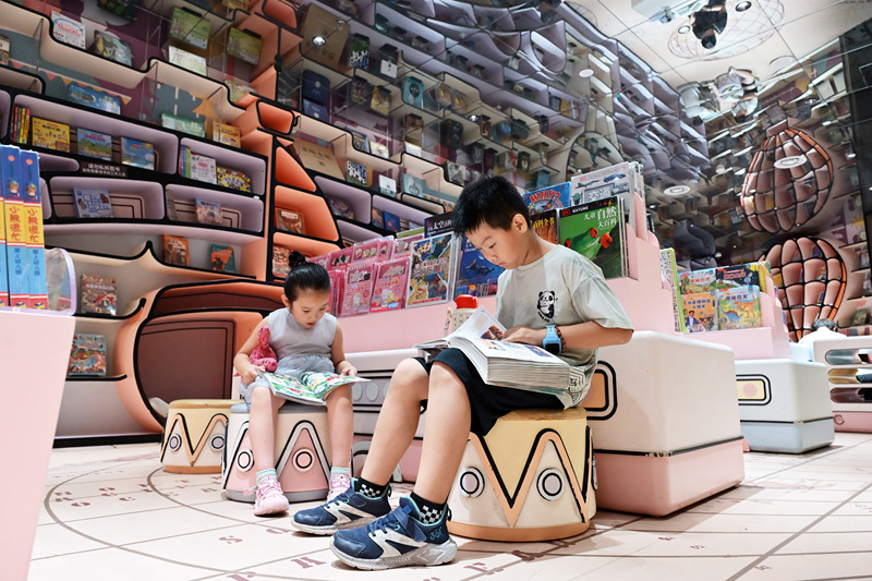 Shijiazhuang: crian?as chinesas leem livros em livraria para passar as férias de ver?o