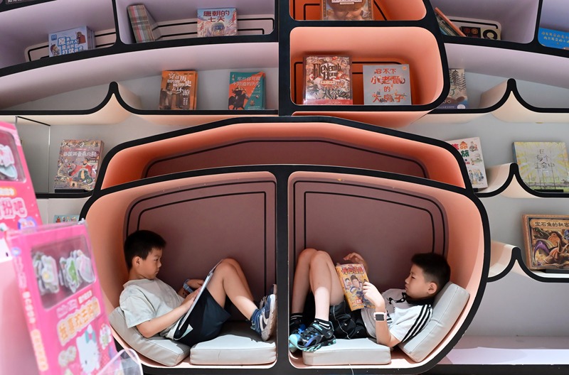 Shijiazhuang: crian?as chinesas leem livros em livraria para passar as férias de ver?o
