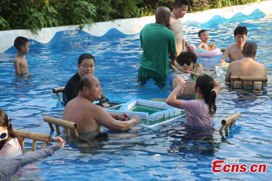 Moradores de Chongqing jogam mahjong na água durante alerta laranja de calor