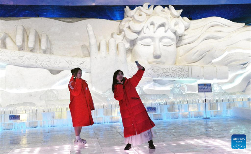 Turistas visitam galeria de arte de gelo e neve reformada do ponto turístico Sun Island em Harbin