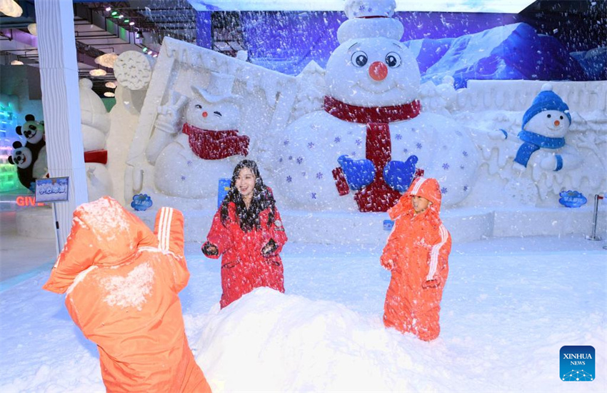 Turistas visitam galeria de arte de gelo e neve reformada do ponto turístico Sun Island em Harbin