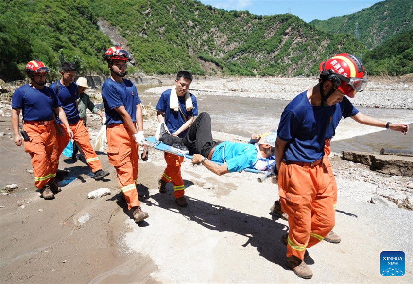 Equipes de resgate evacuam moradores retidos e limpam locais danificados em áreas afetadas por enchentes em Beijing